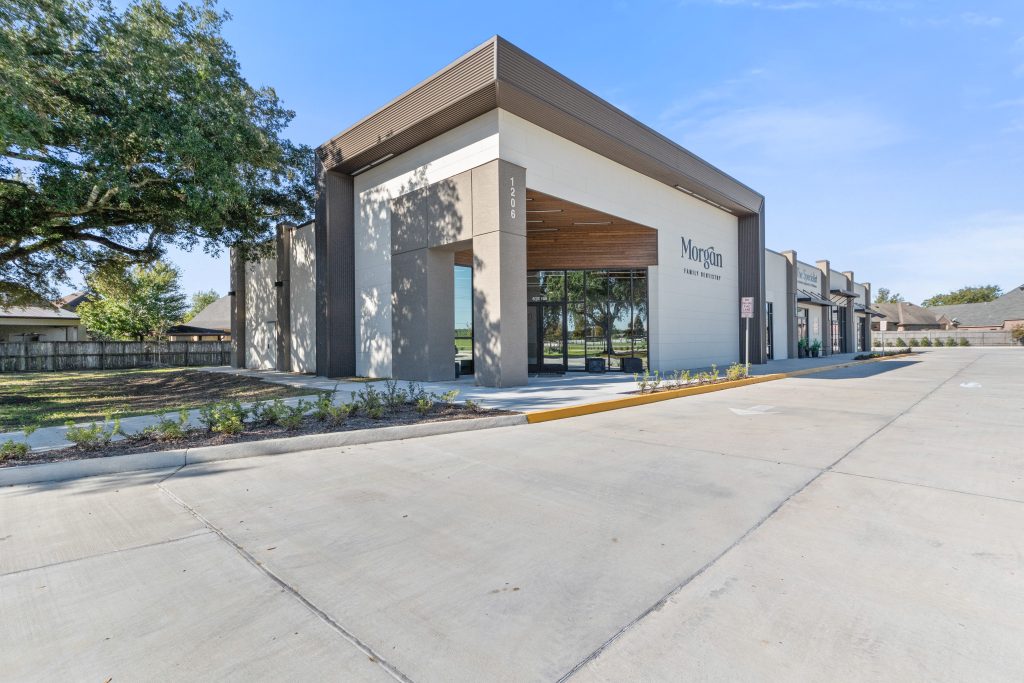 Daytime exterior of Morgan Family Dentistry at Oak Center Development showing wood-accented entry canopy and contemporary commercial facade by A Beazley Architecture
