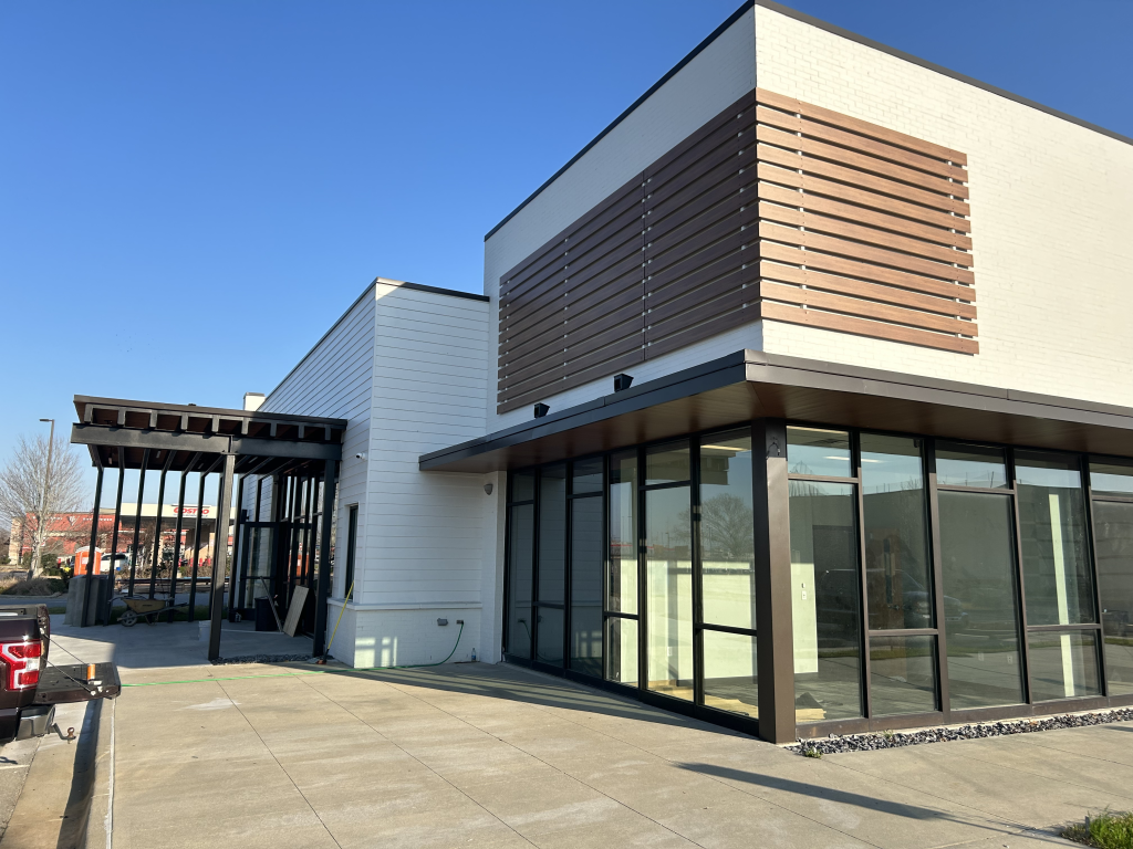 Daytime exterior of CLB The Community Bank Lafayette showing modern canopy entrance, wood slats, and adjacent commercial setting